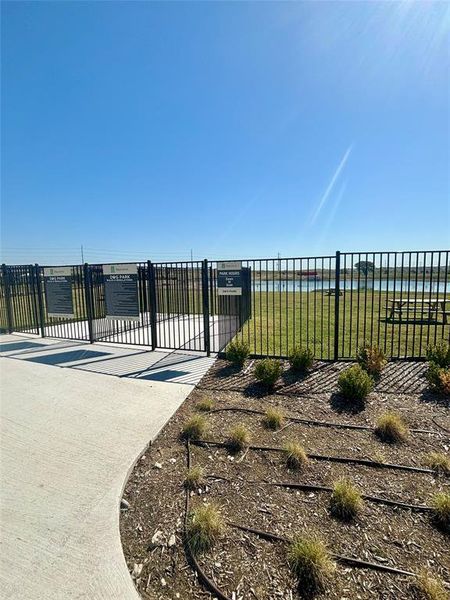 View of gate with a lawn and a water view