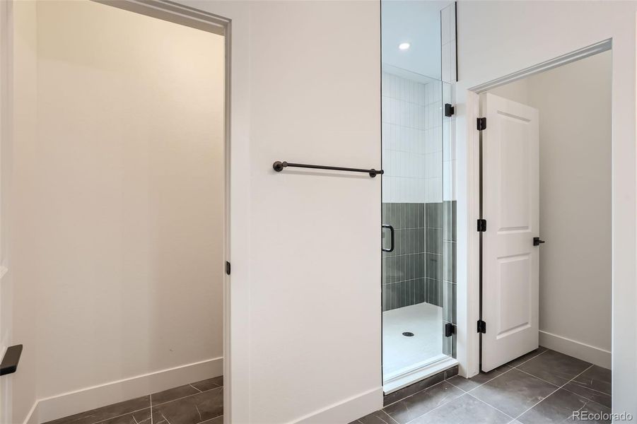 Primary bathroom with spacious shower, private water closet, and extra storage closet.