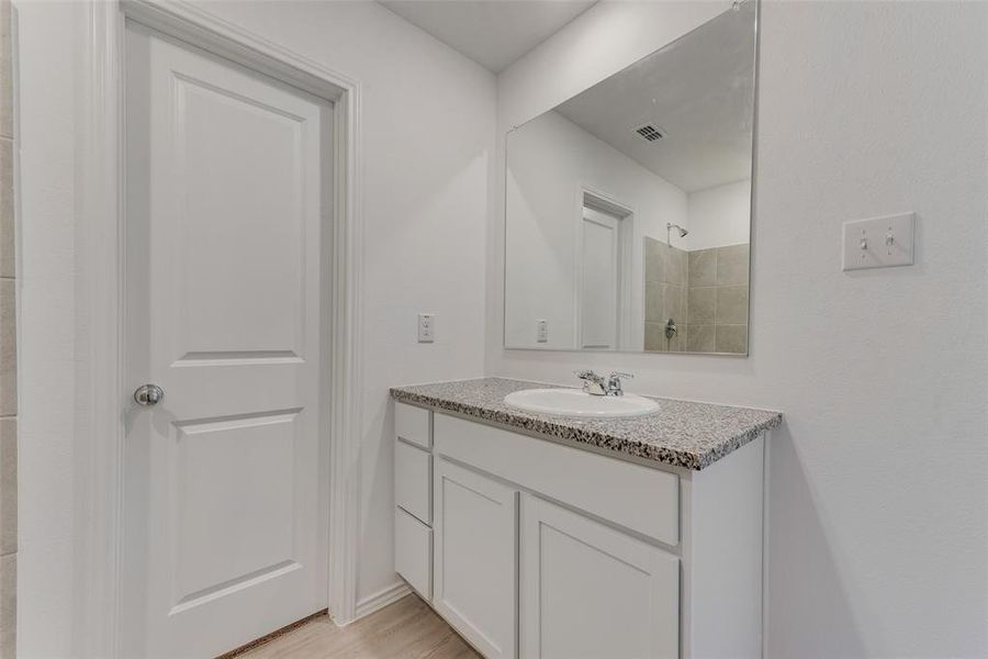 Bathroom with walk in shower, vanity, and hardwood / wood-style floors