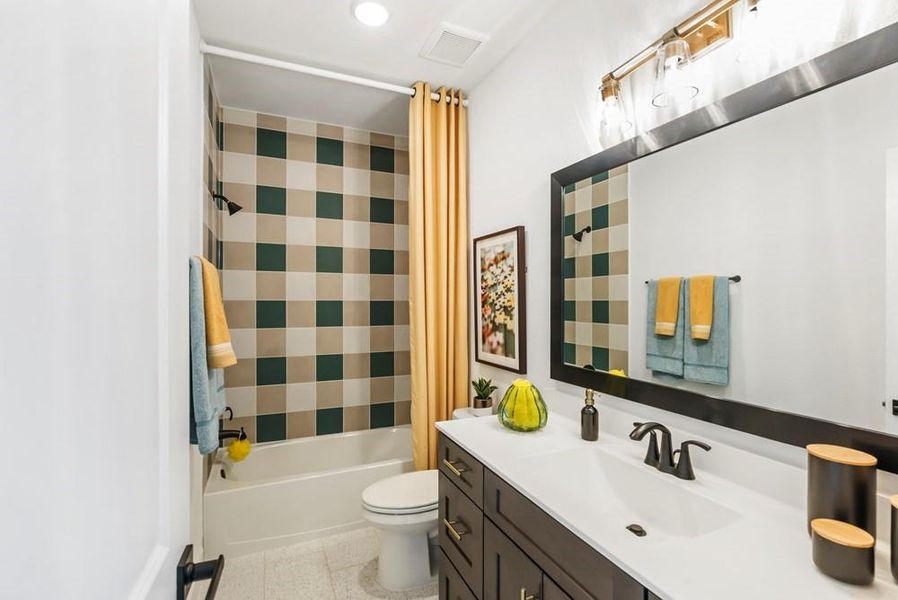 The secondary bathroom features playful shower tile that extends all the way to the ceiling, adding a touch of fun and style to the space. It also includes a 54" vanity with 6 drawers and 2 cabinets, to help maintain a sleek and organized look.