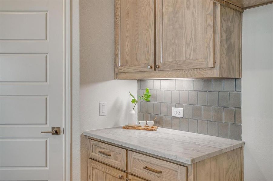 Kitchen with natural stained cabinets, leathered Quartzite and decorative backsplash