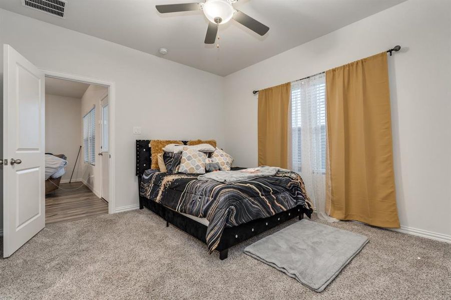 Carpeted bedroom featuring ceiling fan