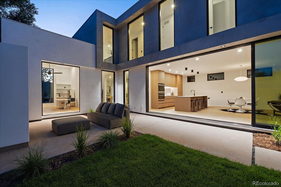 Stacking glass doors in living room and flexible office opened at night