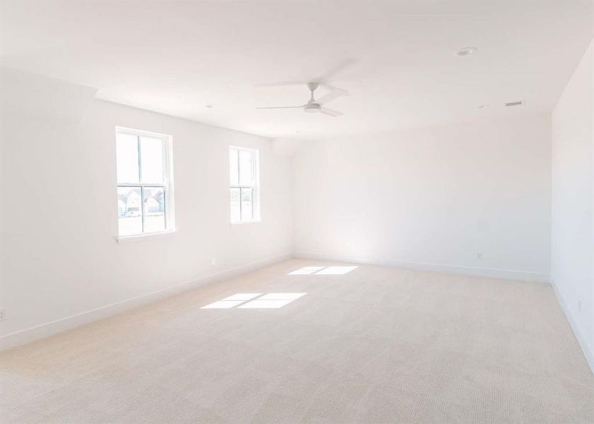 Empty room featuring ceiling fan and light colored carpet