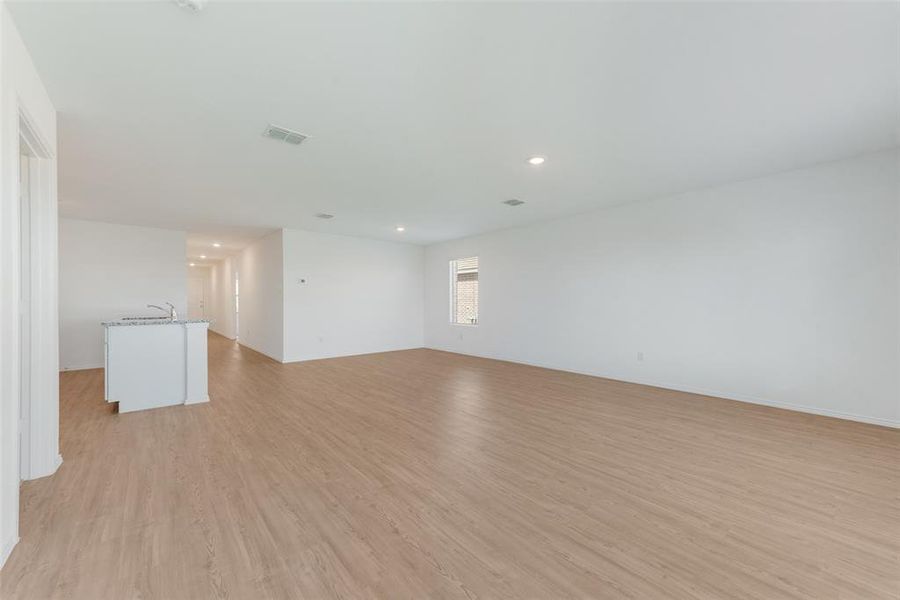 Empty room with light hardwood / wood-style floors and sink