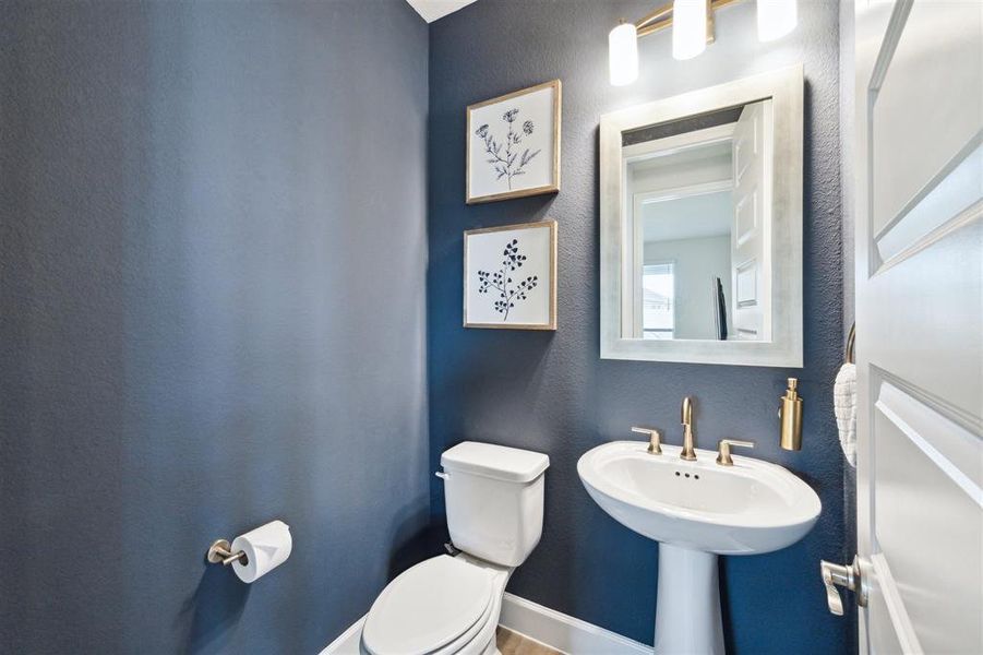 The half-bath powder room features a pedestal sink.