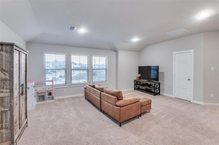 Living room featuring lofted ceiling and light colored carpet