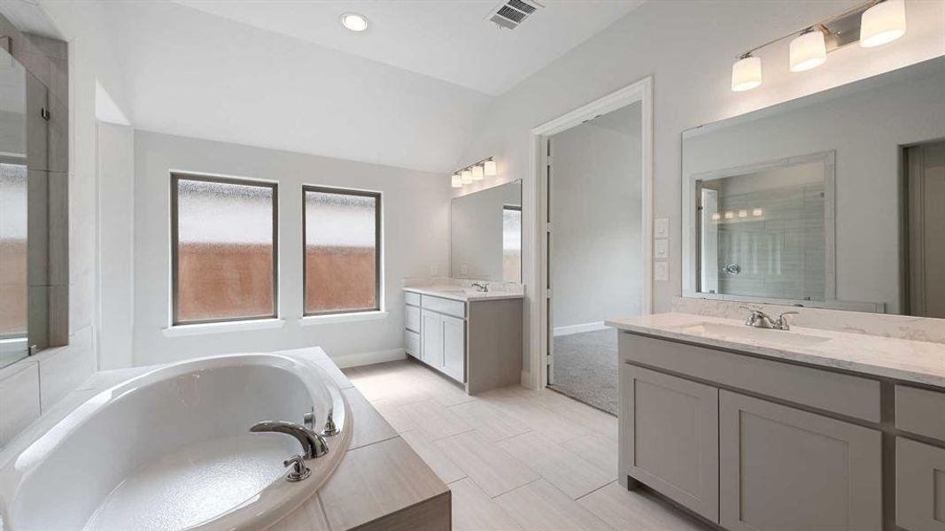 Bathroom featuring vanity, lofted ceiling, and plus walk in shower