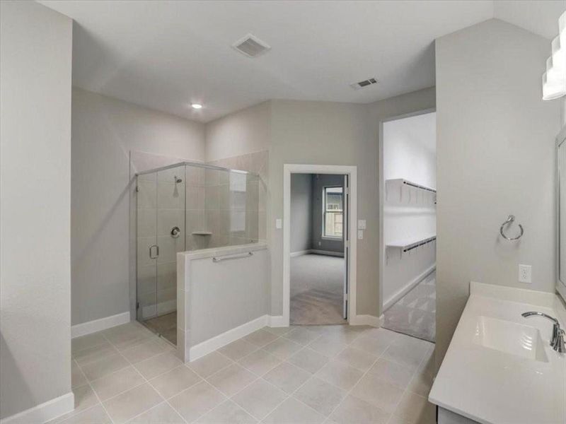 Primary bathroom with a luxurious tub and sleek standing shower for a spa-like experience.