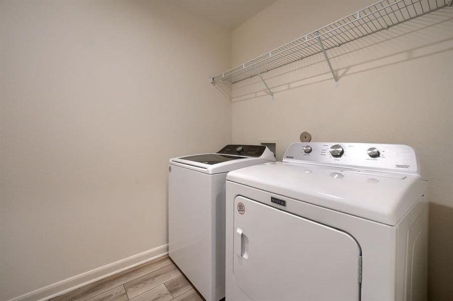 Laundry room featuring washing machine and dryer and light wood-type flooring