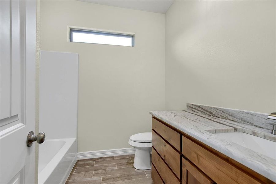 Bathroom featuring vanity and toilet. Mirrors now installed