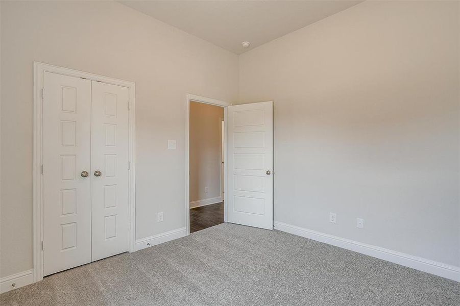 Unfurnished bedroom featuring dark carpet and a closet