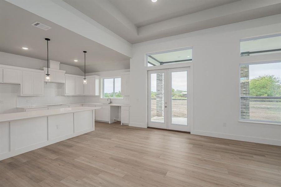 Kitchen with pendant lighting, light hardwood / wood-style flooring, sink, and white cabinets