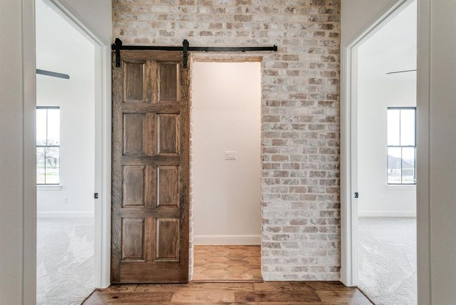 Hall with hardwood / wood-style flooring and a barn door