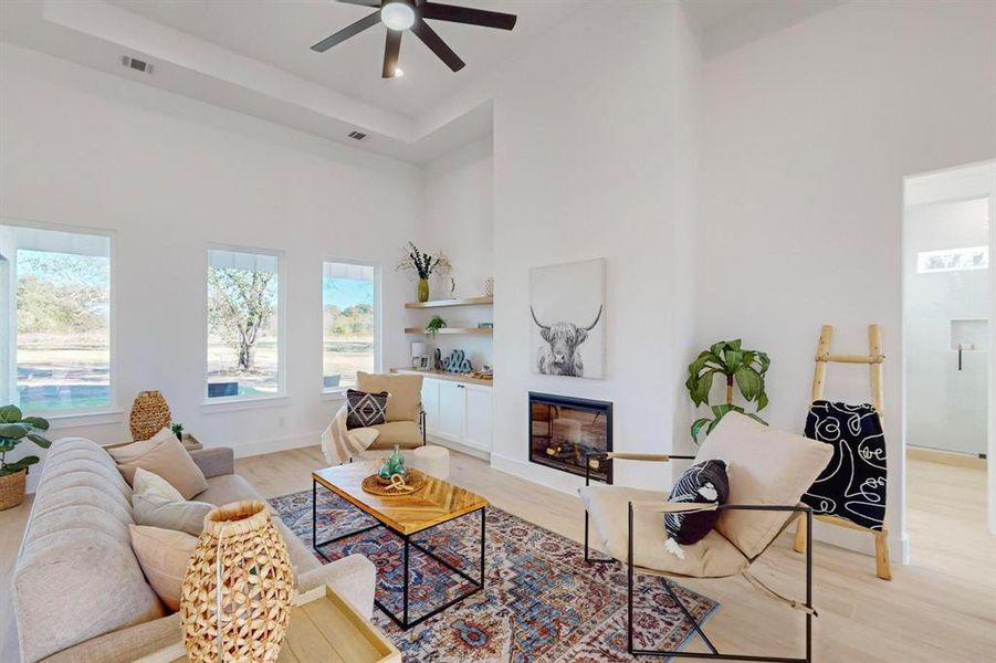 Living room with a towering ceiling, a wealth of natural light, and light wood-type flooring