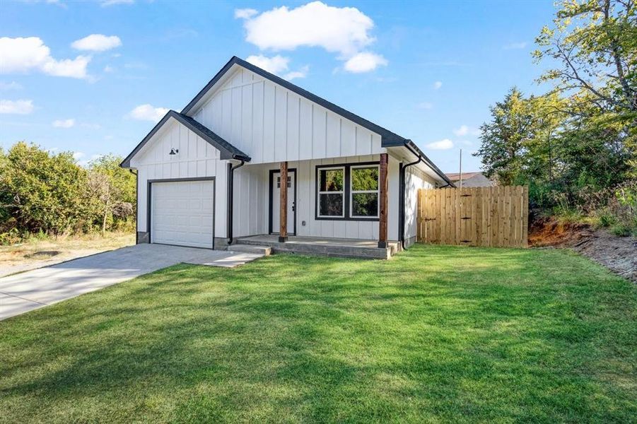 Modern farmhouse featuring a front lawn and a garage