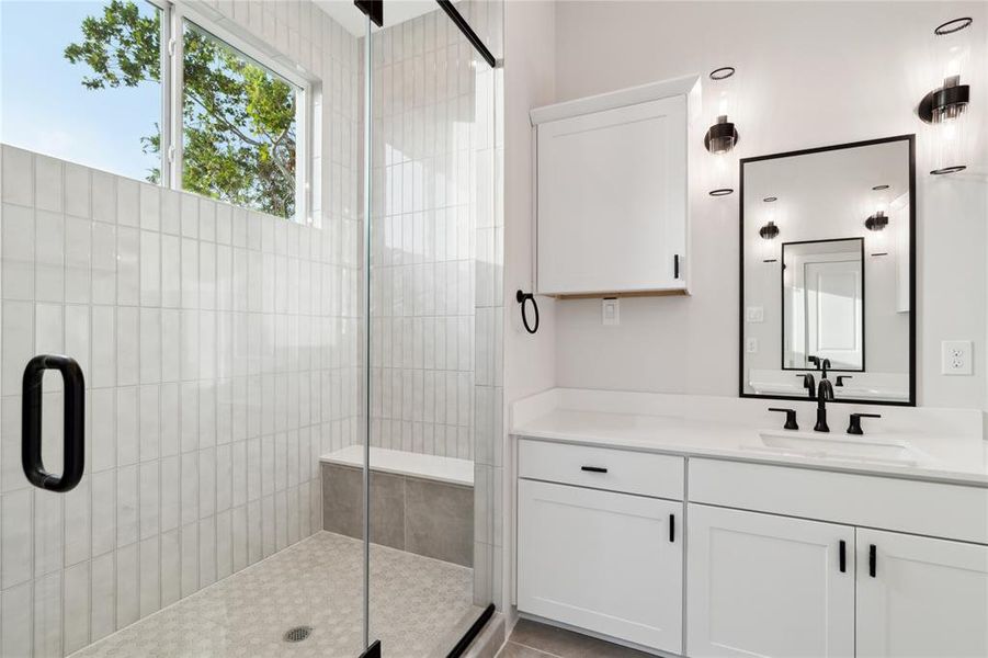 This walk-in shower come standard oversized with floor to ceiling tile and shower bench along an oversized window.