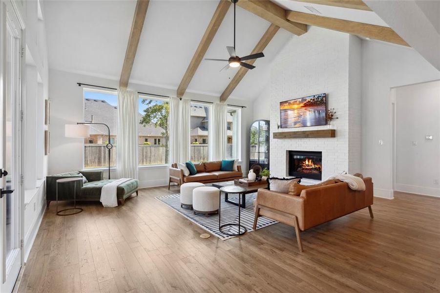 Open living space with cathedral ceilings, engineered wood floors, gas fireplace and abundant natural lighting