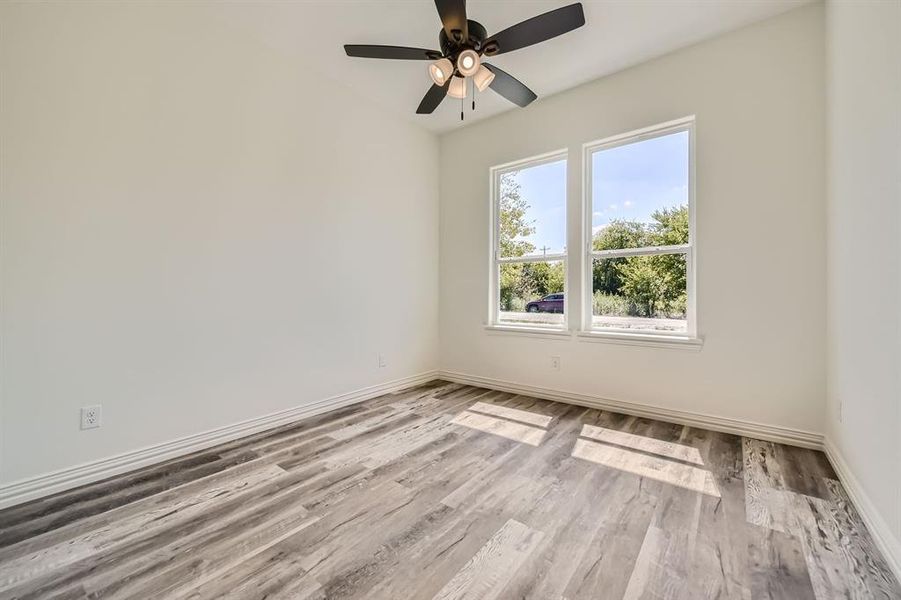 Unfurnished room featuring ceiling fan and light wood-type flooring