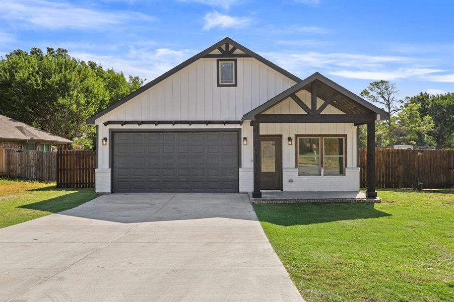 View of front of home featuring a garage and a front lawn