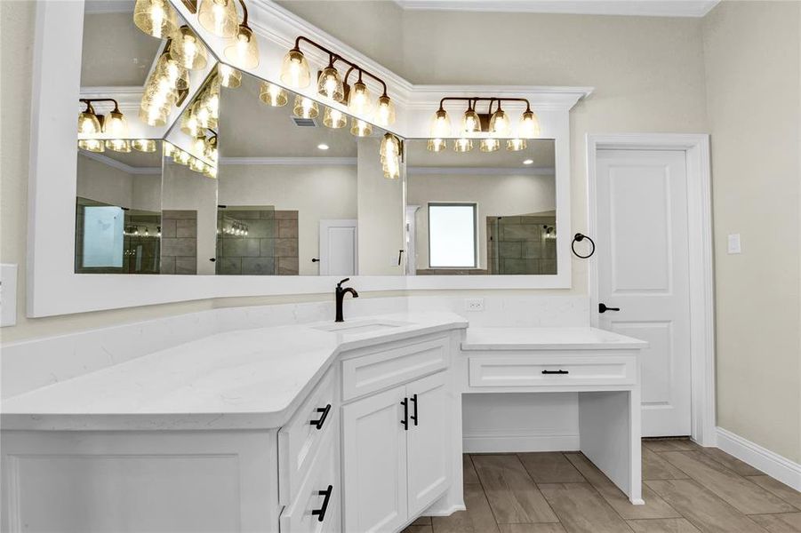 Bathroom featuring a shower with door, crown molding, and vanity