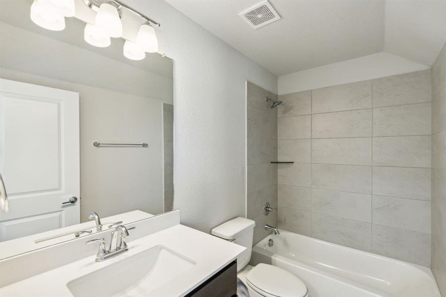 Full bathroom featuring vanity, toilet, and tiled shower / bath