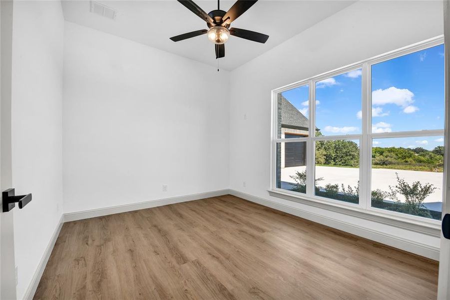 Empty room featuring ceiling fan and light hardwood / wood-style floors