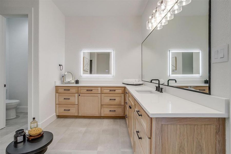 Bathroom with vanity, toilet, and tile patterned flooring