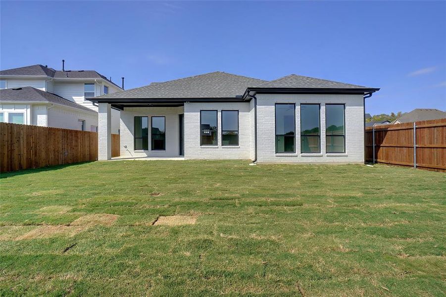 Rear view of property with a yard and a patio area