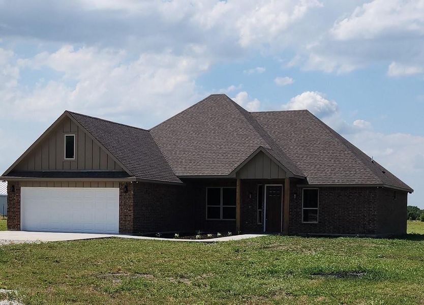 View of front of house featuring a garage and a front yard