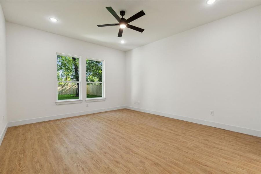 Empty room with light wood-type flooring and ceiling fan