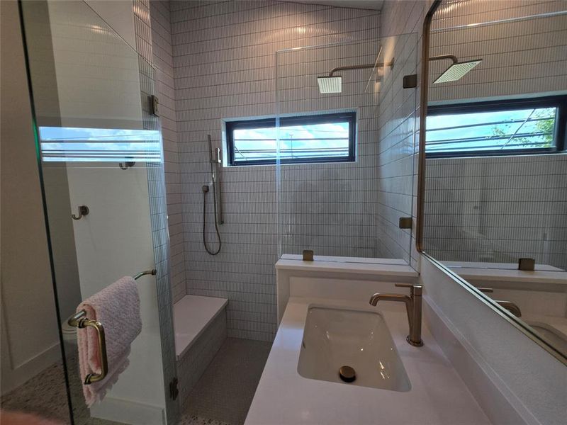 Primary bath walk in shower with a bench and various showering options.