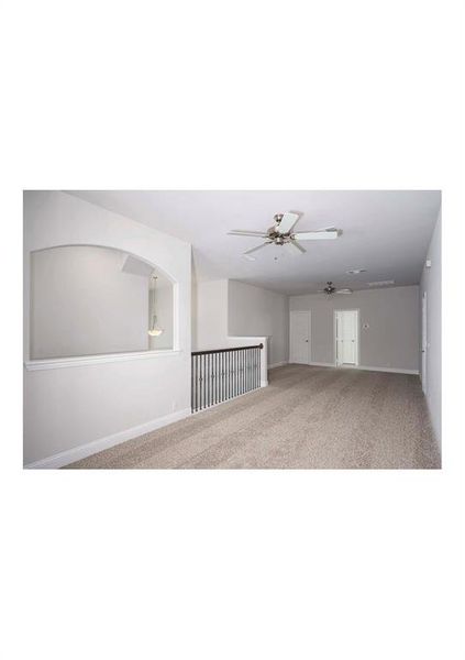 Carpeted spare room featuring ceiling fan