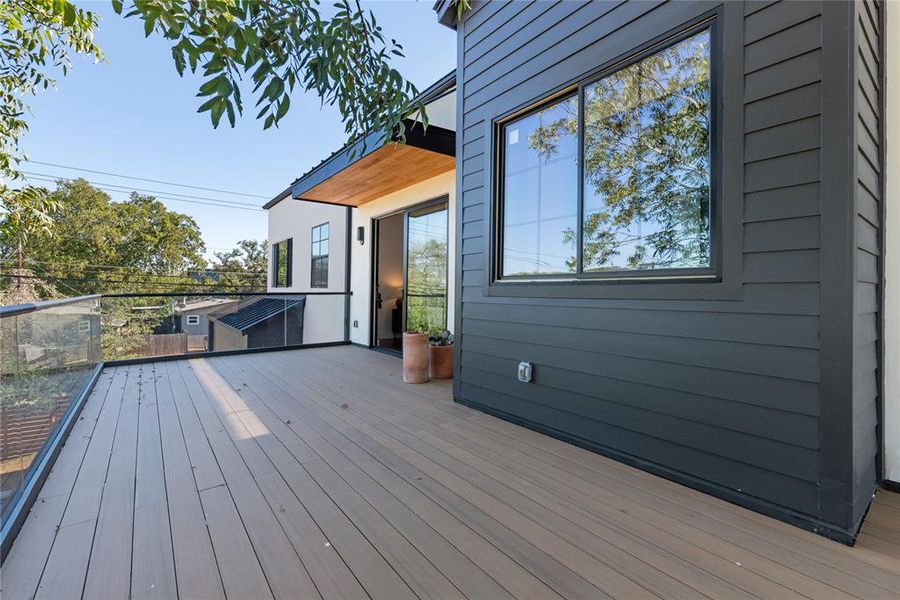 Outdoor deck off primary bedroom overlooks the pool