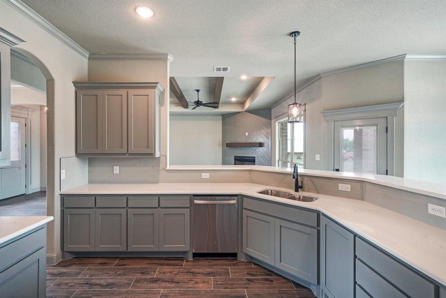 Kitchen featuring tasteful backsplash, dishwasher, ceiling fan, dark hardwood / wood-style floors, and sink