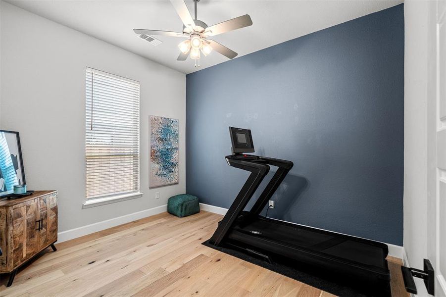 Exercise room with plenty of natural light, ceiling fan, and light hardwood / wood-style flooring