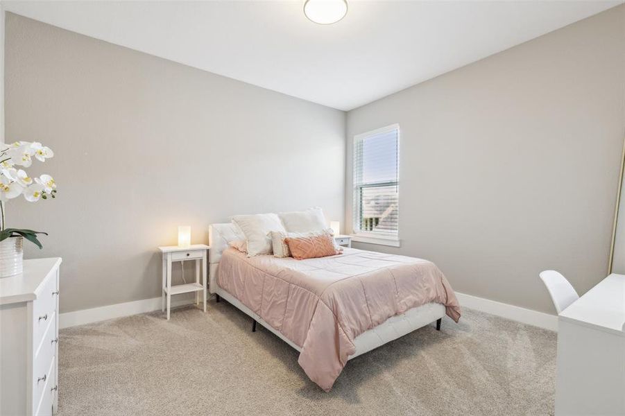 Bedroom featuring light carpet