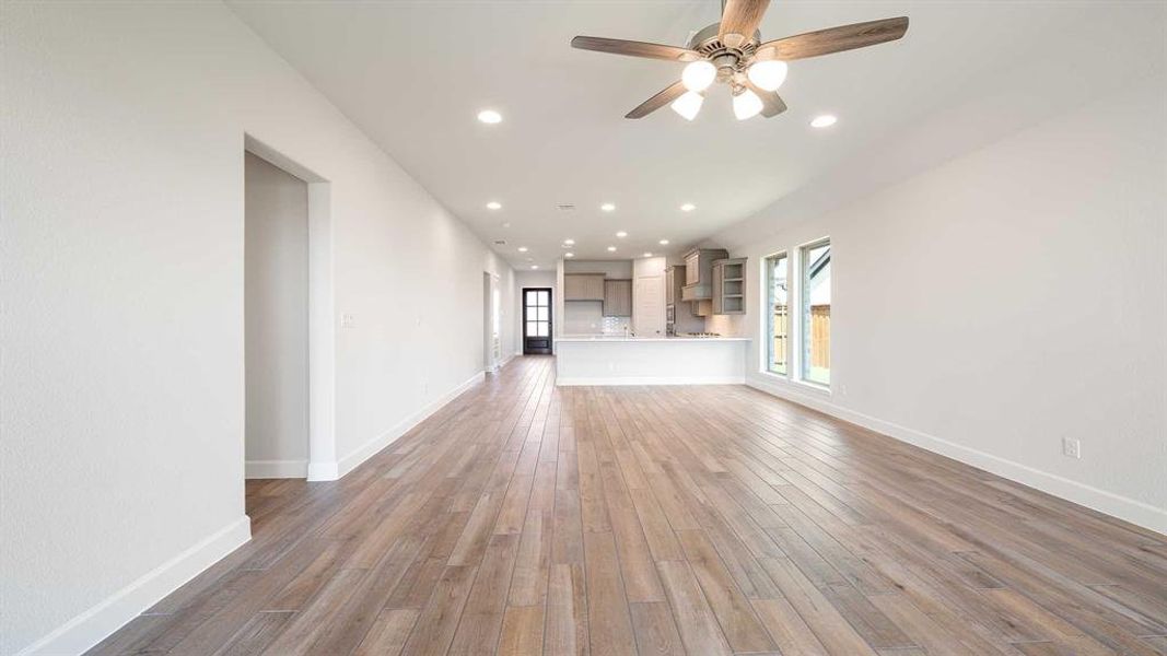 Unfurnished living room featuring hardwood / wood-style floors and ceiling fan