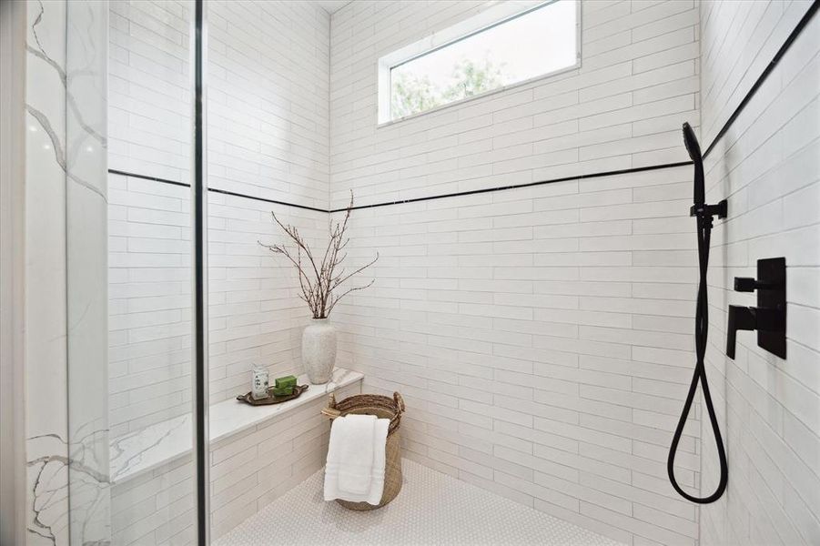 You will love relaxing in this spacious shower with a mixture of classic tile selections  and stylish black hardware