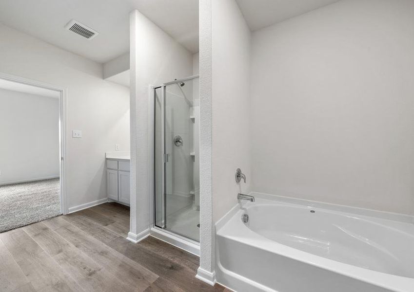 The master bathroom of the Driftwood has a glass, walk-in shower and garden tub.