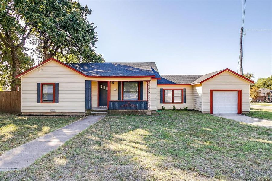 Single story home with covered porch, a front yard, and a garage