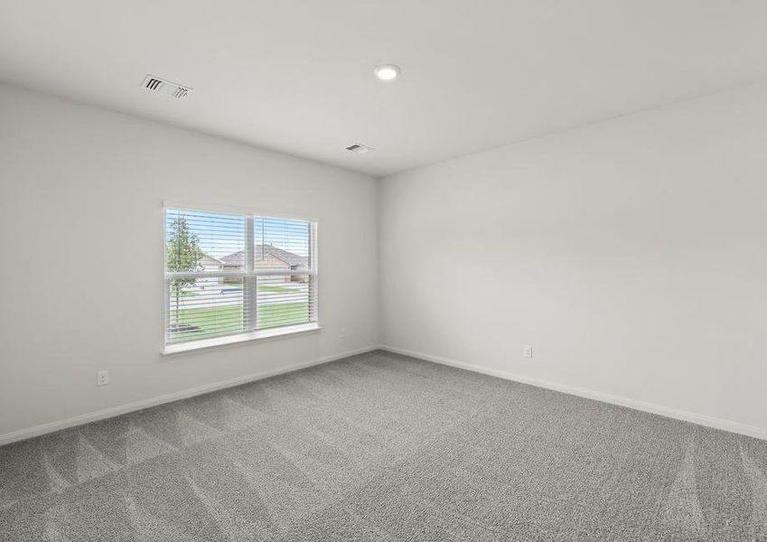 The large master bedroom has a window that lets in natural light and backyard views.