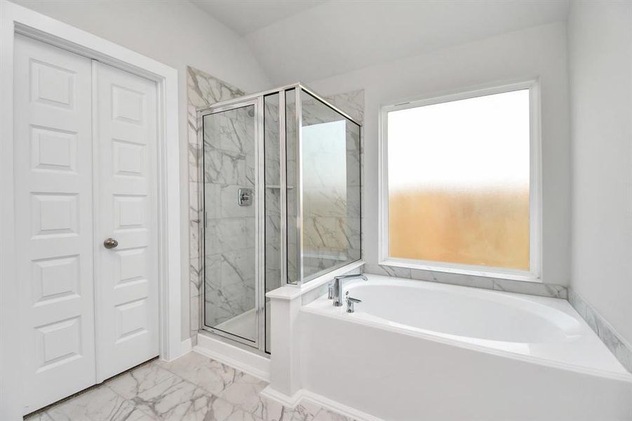 Extra glimpse into the primary bathroom featuring a spacious walk-in closet, adding an extra touch of convenience and luxury to your daily routine. Sample photo of completed home with similar floor plan. As-built interior colors and selections may vary.