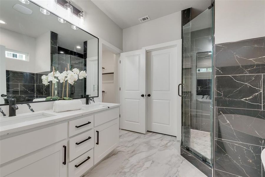 Bathroom with a shower with door, double vanity, and tile patterned flooring