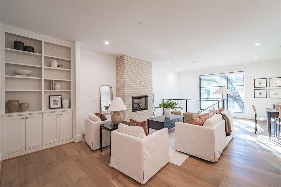 Living room with light hardwood / wood-style flooring and a fireplace