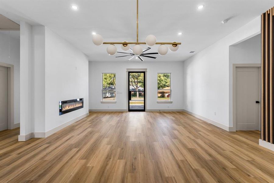 Unfurnished living room with a notable chandelier and light hardwood / wood-style floors