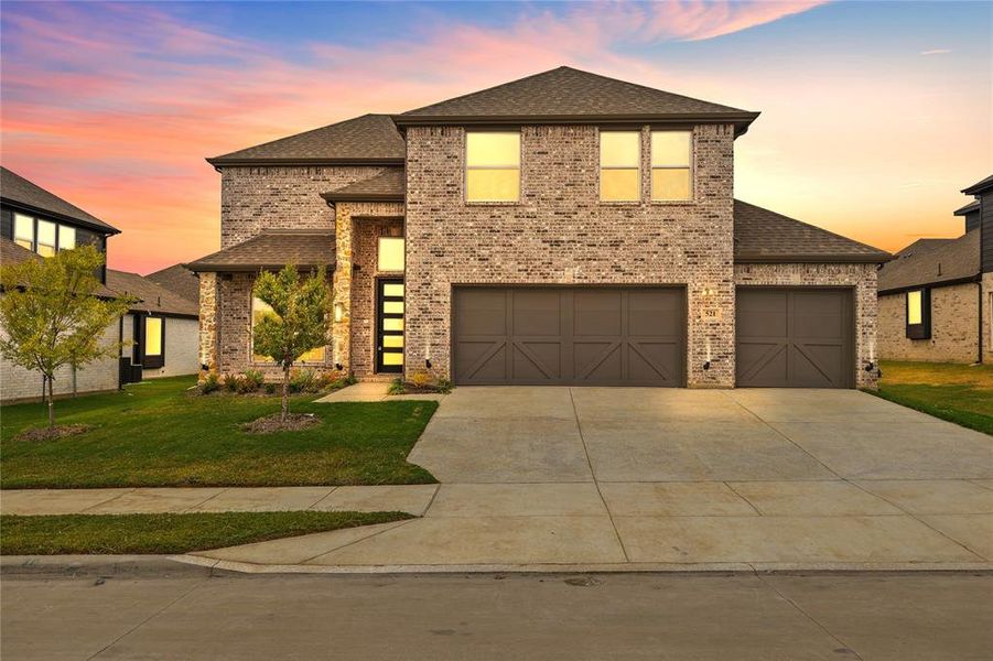 View of front of home featuring a garage and a lawn