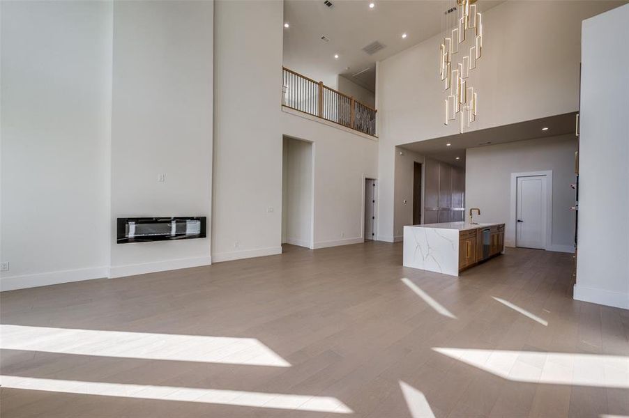 Unfurnished living room with heating unit, a high ceiling, and hardwood / wood-style floors