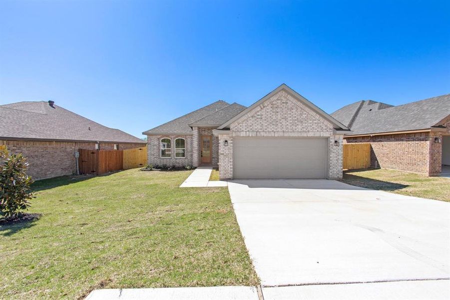 View of front of property with a garage and a front lawn