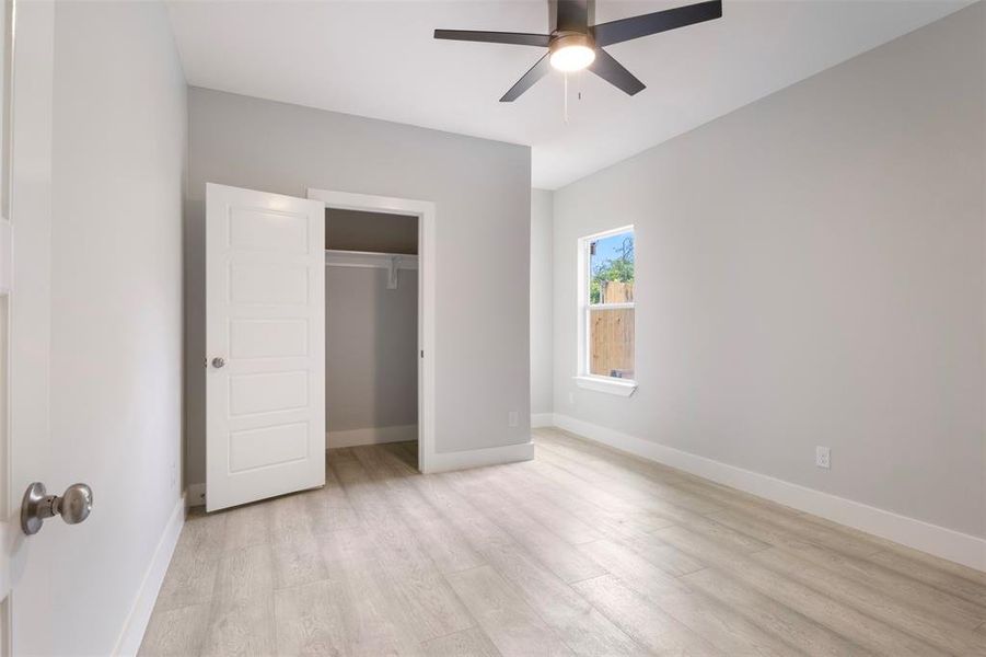 Unfurnished bedroom featuring a closet, ceiling fan, and light wood-type flooring